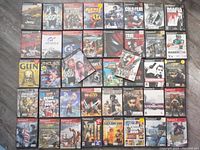 All 42 Playstation 2 game cases laid out in rows on wood floor