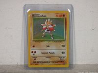 Front side of the Hitmonchan holographic Pokemon card showing character art and game info.