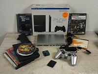 Console, controller, memory cards, upgrade disc, cables, original box and one game case visible