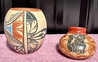 Photo showing two vintage Native American pottery pieces, one with geometric/floral design and other with cat motif.
