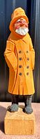 Full view of the wooden carved Old Sea Captain statue showing the full figure with detailed clothing and facial features.