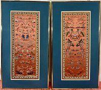 Pair of framed embroidered silk sleeve panels, each measuring about 22x9 inches, shown side by side with blue matting and gold frames