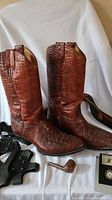 Paired brown alligator leather cowboy boots shown upright and side by side