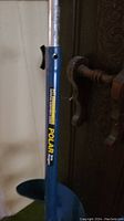 Close-up of blue metal auger labeled 'Polar' showing the handle and part of the spiral blade