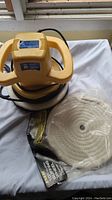 Orbital polisher next to unopened pack of 10-inch buffing pads