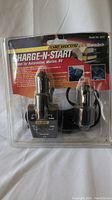 Front view of the Charge-N-Start 12 Volt charger sealed in original packaging showing two plugs and cable.
