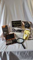 Full set of gold prospecting related items with books, scale, magnifier, gold flakes pouch and map.