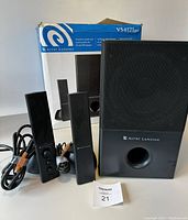 Front view showing subwoofer, two satellite speakers, cables, and original box with Altec Lansing VS4121 branding.