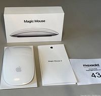 Apple Magic Mouse 2 with original box, paperwork, and MaxSold lot tag visible.