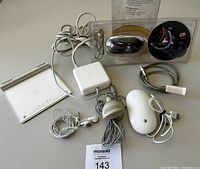 Overview photo of all accessories including Apple Magic Trackpad, MagSafe power adapter, earbuds, microphone, Mighty Mouse, Macally mouse and USB keyboard cable.