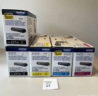 Image showing five unopened Brother toner cartridges in original packaging: two black, one yellow, one cyan, and one magenta.