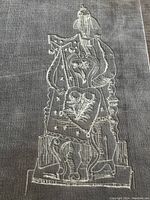 Close-up of embossed design on grey velour cover of 'Dada & Surrealist Art' showing detailed abstract art with some oxidation visible