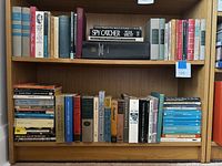 Bookshelves filled with hardcover and paperback books including Penguin and various classic literature and non-fiction titles.