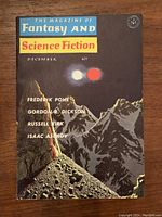 Front cover: December issue with mountain scene, two planetary bodies, lists Frederik Pohl, Gordon R. Dickson, Russell Kirk, Isaac Asimov