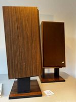 Pair of speakers on stands, front and side view