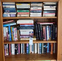 Full bookshelf view showing a variety of books in hardcover and softcover across genres including classics and modern works.