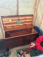 Open lid showing cedar lining and three compartments on top inside the chest.