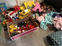 Overview of vintage Fisher-Price toys, dolls, toys in box, dolls clothes, McDonald's plate set and blocks