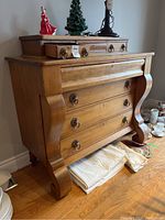 Front-right angle view showing overall two-tier structure, curved legs and lower drawers
