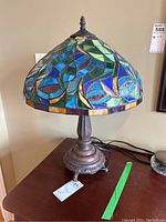 Full view of lamp showing stained glass shade and metal base