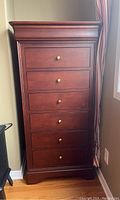 Front view of six-drawer dresser with dark cherry finish and brass knobs