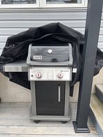 Front view of Weber Spirit propane gas grill with cover partially removed