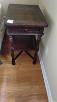 Full view of antique wooden writing table showing drawer, bottom shelf, and turned legs.