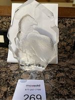 Clear crystal sculpture of an eagle with etched feather details, placed on a countertop with a white background and a MaxSold tag labeled 269 in front.