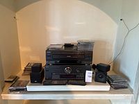Photo showing the stereo equipment with CDs and remote controls on shelf