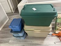 Stacked Rubbermaid bins of different sizes and colors showing green, beige, blue bins