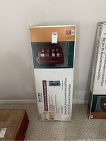 Photo of sealed Slidex media storage cabinet in box showing front and side of packaging with product image and information.