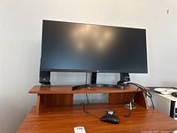 LG ultrawide curved monitor on desk with Logitech speakers