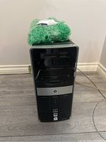 Front view of HP Pavilion Elite m9080n desktop computer tower with bubble wrap on top, showing overall condition and design.