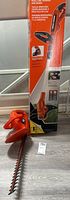 Photo showing boxed hedge trimmer and loose grass trimmer head part.