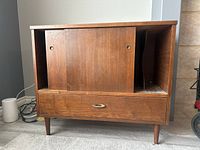 Front view of the wooden record cabinet showing sliding doors and bottom drawer
