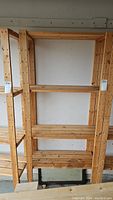 Full front view of wooden shelf unit showing five shelves and side supports.