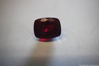 Top view of loose red gemstone on white background