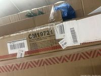 Boxed artificial Christmas tree in its original shipping box with visible shipping labels and barcodes.