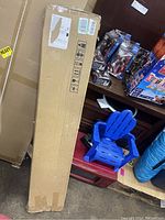 Tall rectangular sealed cardboard box containing the cargo cover for Audi Q7.