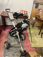 Full view of TaylorMade golf bag on golf push cart, clubs inside the bag.