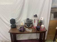 Wide view of kitchen items on a wooden table against a white backdrop