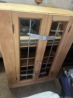 Front view of wooden bookcase with glass grid doors taped shut