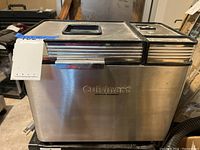 Front and side view of the Cuisinart convection breadmaker showing the stainless steel body and control panel with buttons and display.