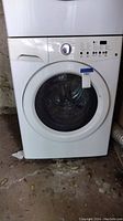 Front view of the white front loading washing machine with control dial and buttons.