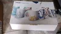Box of Cricut mug press with images of decorated mugs on the exterior.