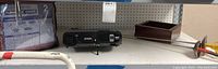 Shelf with Epson EX7220 projector, furniture cover package, wooden box, and gray stick items