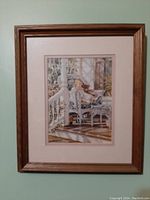 Full view of framed artwork "A Moments Rest" by Trisha Romance, showing the wooden frame and matting with the image of a child on a porch.