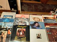 Photo showing front covers of multiple vinyl records including Cat Stevens, ABBA, Boney M., Helen Reddy, The Bells, Midnight, and more.