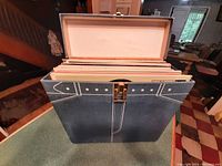 Blue vintage vinyl record carrying case, showing the case open with records upright inside.