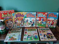 Overview photo showing 9 comic books including Little Archie Digests, Richie Rich titles, and a boxed Best of Archie Comics collection, next to a can of Canada Dry Ginger Ale for scale.